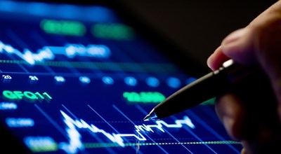 Grafico su un tablet e una mano con una penna che indica l'andamento del flusso